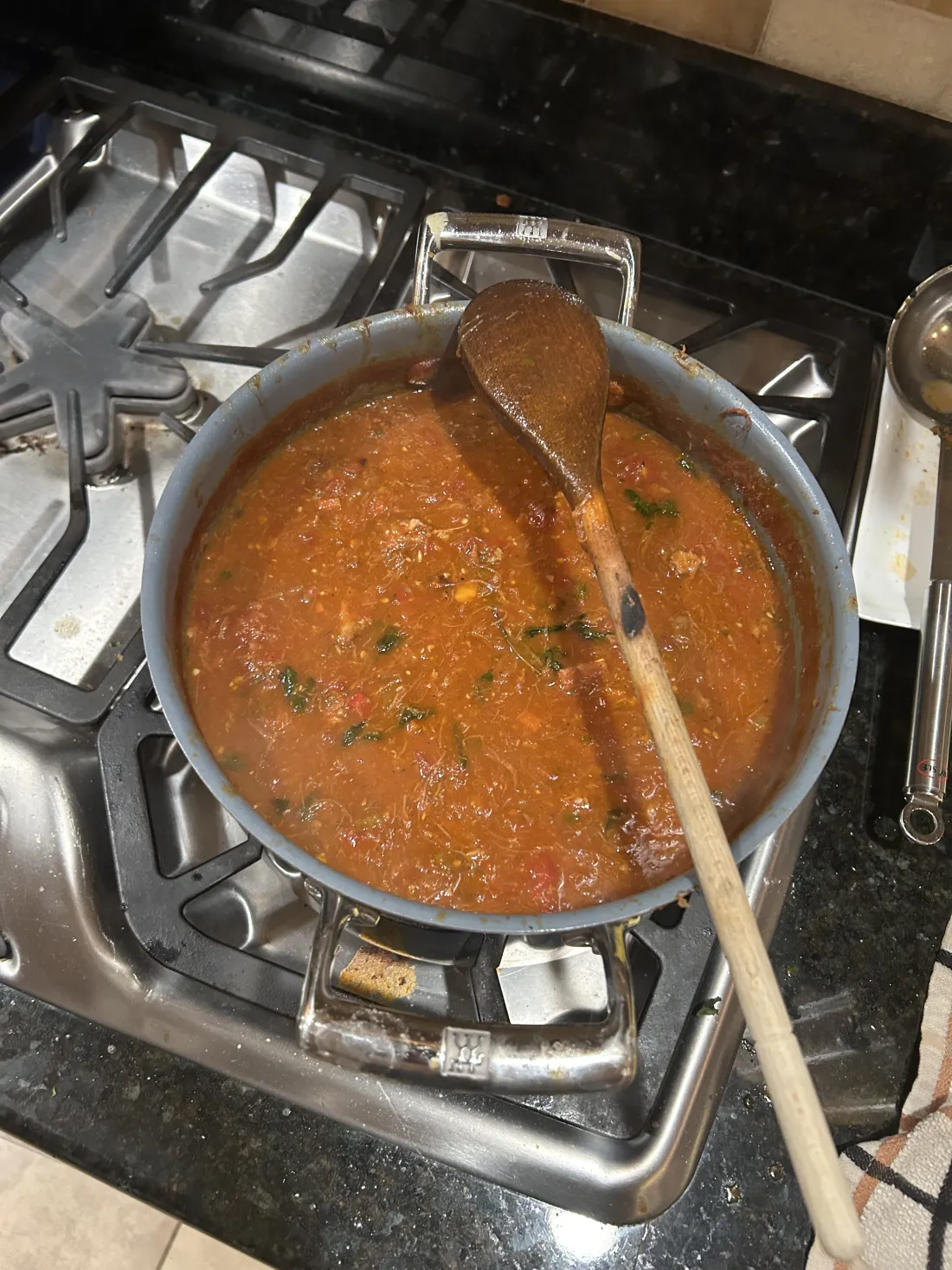 A pot of tomato sauce simmering on the stove