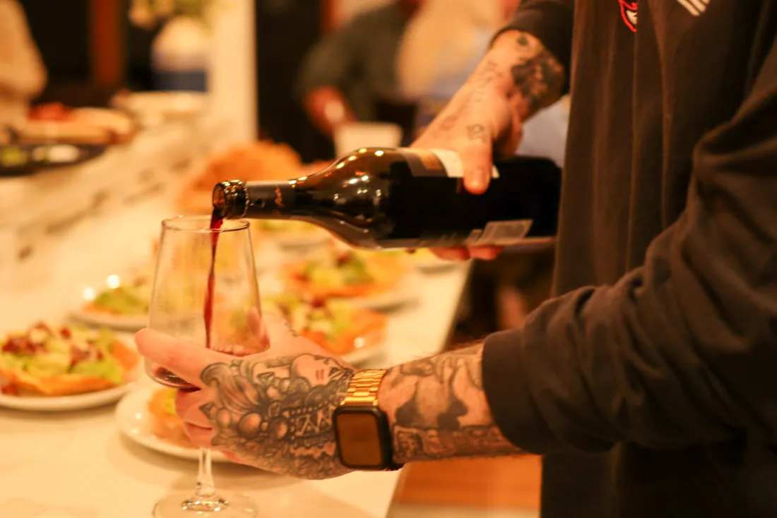 Wine being poured at a set dinner table